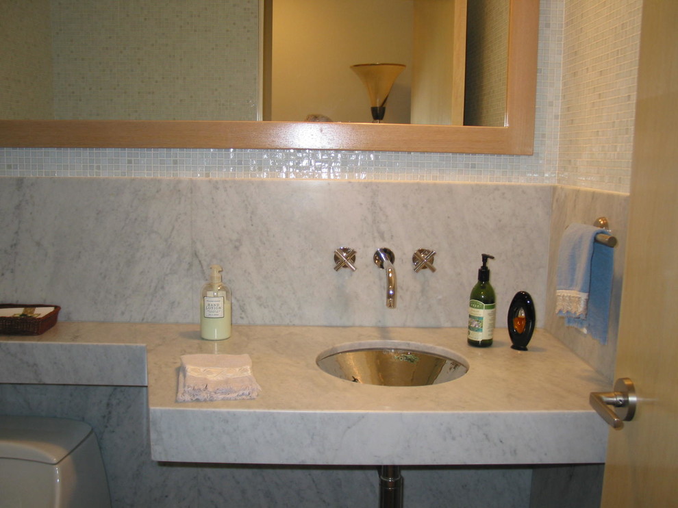 Cette photo montre une grande salle de bain principale tendance avec un carrelage beige, un carrelage métro, un lavabo encastré et un plan de toilette en marbre.