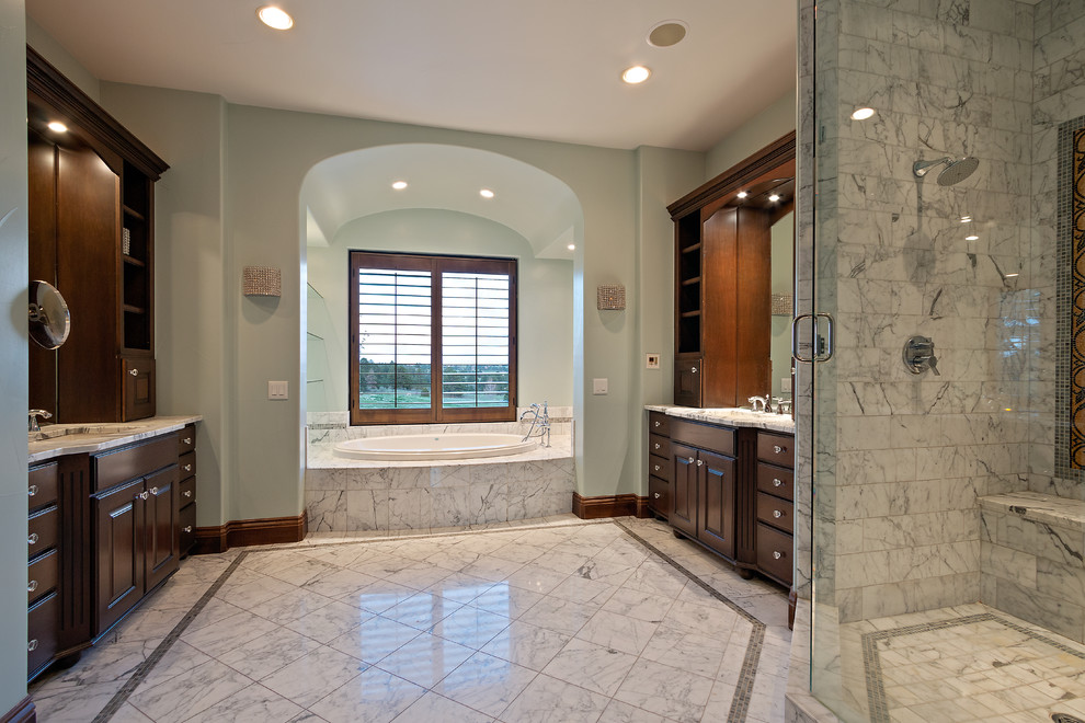 Стильный дизайн: огромная главная ванная комната в средиземноморском стиле с фасадами с выступающей филенкой, темными деревянными фасадами, накладной ванной, душем в нише, серой плиткой, белой плиткой, мраморной плиткой, серыми стенами, мраморным полом, врезной раковиной, мраморной столешницей, белым полом, душем с распашными дверями и белой столешницей - последний тренд