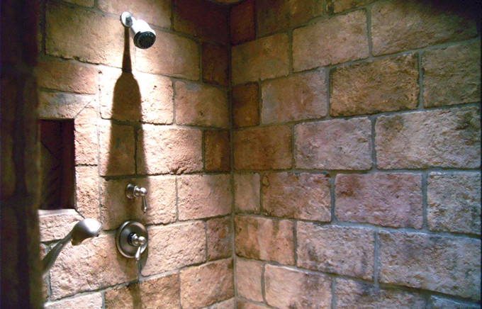 Bild på ett stort rustikt en-suite badrum, med ett nedsänkt handfat, luckor med infälld panel, skåp i mellenmörkt trä, granitbänkskiva, en kantlös dusch, stenkakel och mörkt trägolv