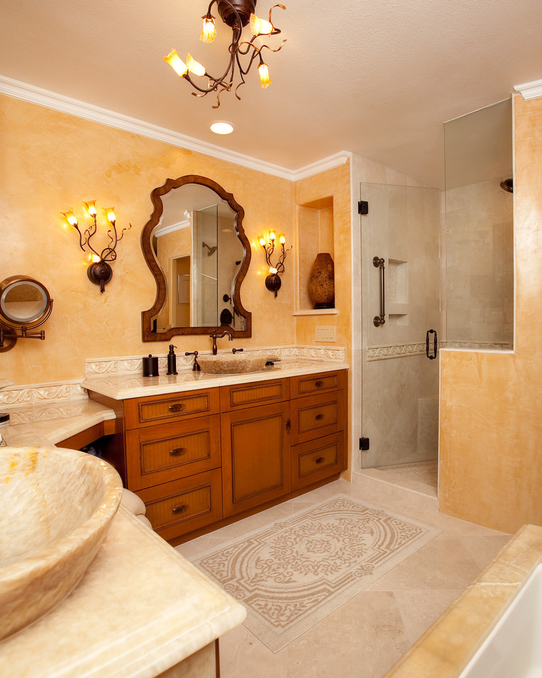 Aménagement d'une grande douche en alcôve principale classique en bois brun avec une vasque, une baignoire posée, un placard avec porte à panneau encastré, un carrelage beige, un mur jaune, un sol en marbre, un sol beige et une cabine de douche à porte battante.