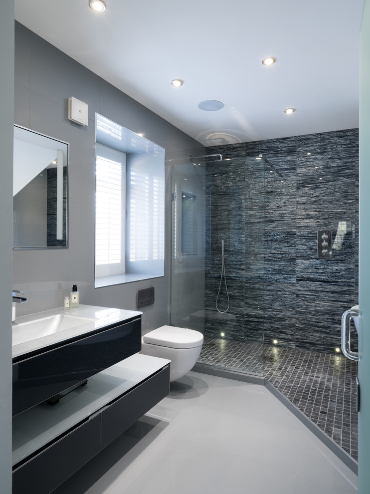 Inspiration för ett stort funkis badrum med dusch, med en öppen dusch, en vägghängd toalettstol, grå kakel, keramikplattor, grå väggar, klinkergolv i keramik, ett väggmonterat handfat och med dusch som är öppen