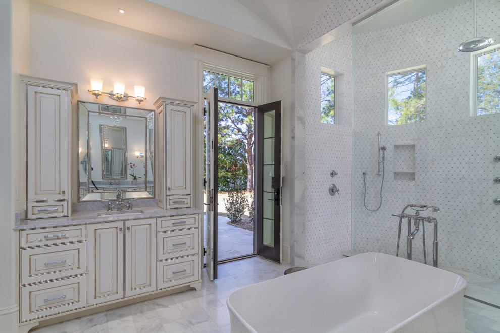 Inspiration for a mediterranean white tile and mosaic tile white floor and vaulted ceiling bathroom remodel in Charlotte with raised-panel cabinets, white cabinets, white walls, an undermount sink, gray countertops and a built-in vanity