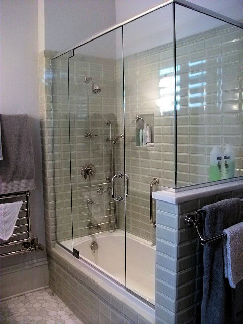 Immagine di una stanza da bagno chic con vasca/doccia, piastrelle verdi, piastrelle di vetro, pareti beige, pavimento con piastrelle in ceramica, pavimento bianco e porta doccia a battente