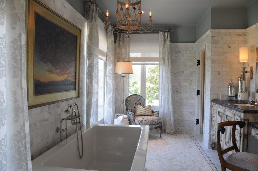 This is an example of a large classic ensuite bathroom in Los Angeles with raised-panel cabinets, distressed cabinets, a freestanding bath, white tiles, marble tiles, grey walls, marble flooring, a submerged sink and white floors.