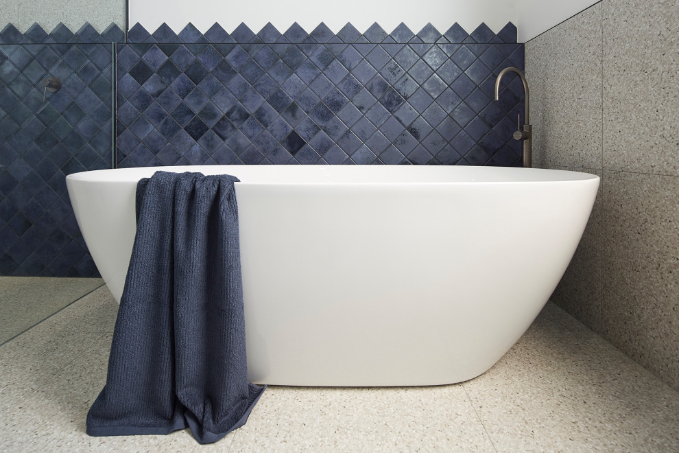 Bathroom - large modern kids' gray tile terrazzo floor and multicolored floor bathroom idea in Melbourne with flat-panel cabinets, blue cabinets, a wall-mount toilet, multicolored walls, a vessel sink, quartz countertops and white countertops