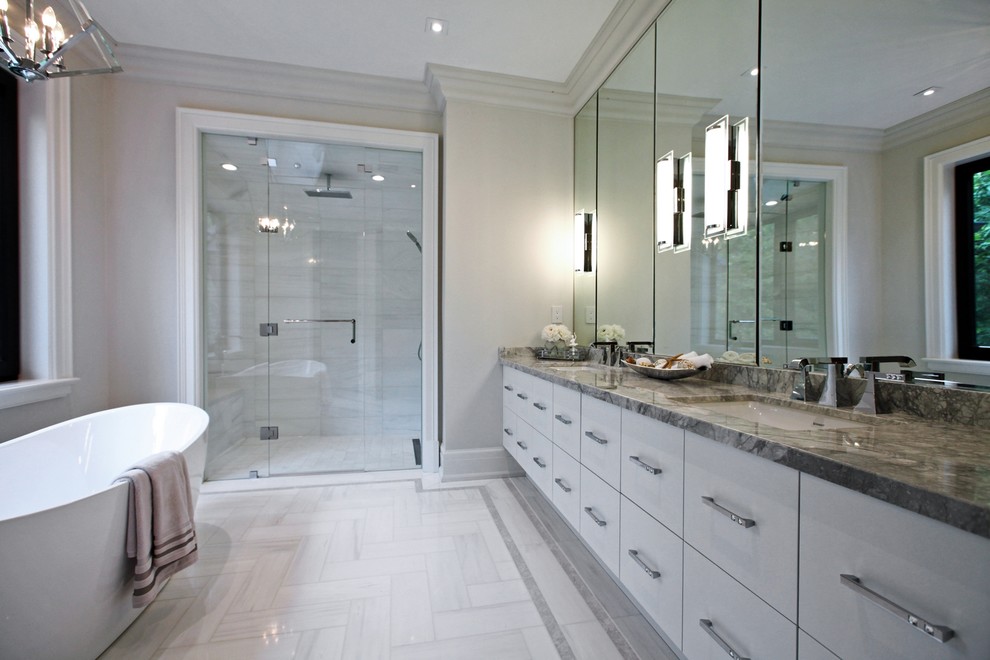 Example of a large transitional master gray tile and porcelain tile porcelain tile and beige floor bathroom design in Toronto with flat-panel cabinets, white cabinets, beige walls, an undermount sink, granite countertops and a hinged shower door