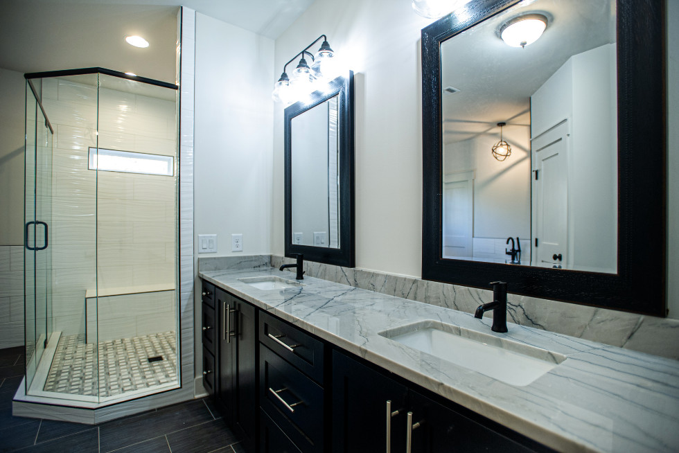 Пример оригинального дизайна: большая главная ванная комната в стиле кантри с фасадами в стиле шейкер, черными фасадами, отдельно стоящей ванной, угловым душем, раздельным унитазом, белой плиткой, каменной плиткой, белыми стенами, полом из керамической плитки, врезной раковиной, столешницей из известняка, черным полом, душем с распашными дверями и серой столешницей