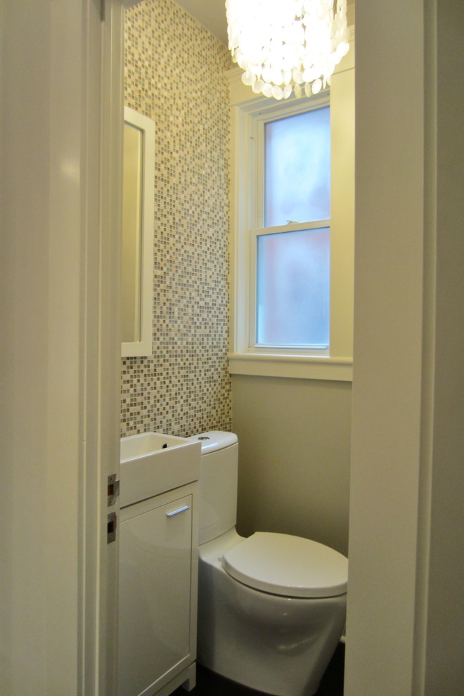 Esempio di un piccolo bagno di servizio moderno con lavabo a consolle, ante lisce, ante bianche, WC monopezzo, piastrelle multicolore, piastrelle di vetro, pareti grigie e parquet scuro