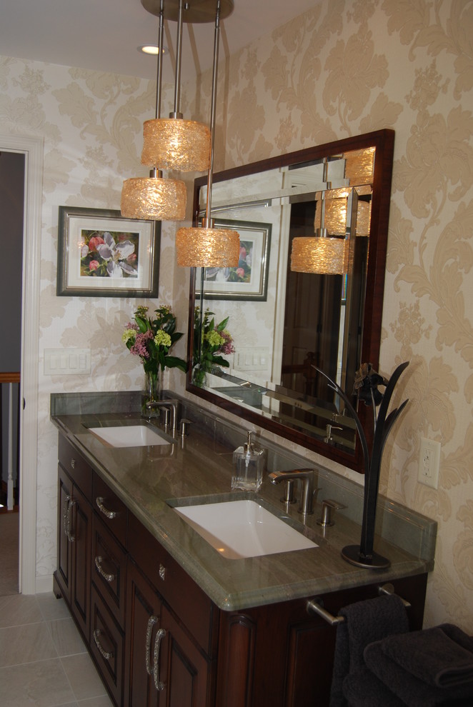 Exemple d'une salle d'eau chic en bois foncé de taille moyenne avec un placard avec porte à panneau surélevé, un plan de toilette en granite, un mur beige, sol en béton ciré et un lavabo encastré.