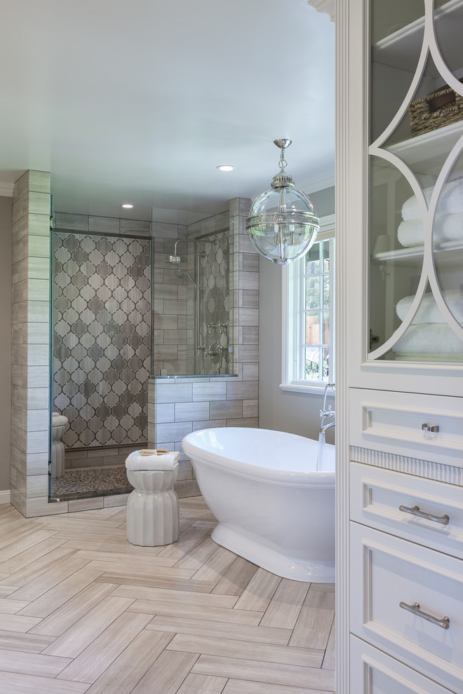 Свежая идея для дизайна: главная ванная комната в стиле неоклассика (современная классика) с фасадами с утопленной филенкой, отдельно стоящей ванной, душем в нише, серой плиткой и серыми стенами - отличное фото интерьера