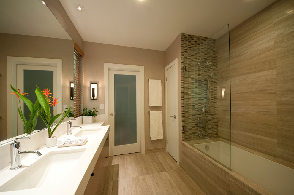 Trendy gray tile and stone tile tub/shower combo photo in Hawaii with an undermount sink, flat-panel cabinets, medium tone wood cabinets, quartzite countertops, an undermount tub and a two-piece toilet