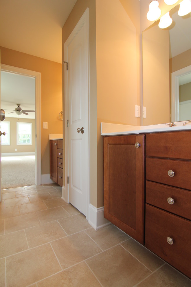 Immagine di una stanza da bagno classica di medie dimensioni con ante con riquadro incassato, ante in legno scuro, piastrelle beige, piastrelle in ceramica, pareti beige e pavimento con piastrelle in ceramica
