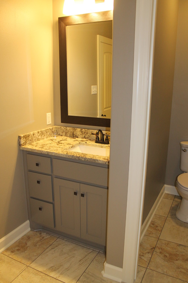 Mid-sized elegant porcelain tile and brown floor bathroom photo in Little Rock with shaker cabinets, beige cabinets, a two-piece toilet, brown walls, an undermount sink, granite countertops and beige countertops