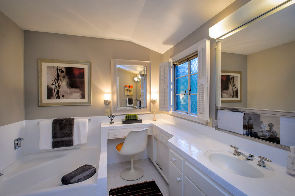 サンフランシスコにあるコンテンポラリースタイルのおしゃれな浴室 (一体型シンク、コーナー型浴槽、照明) の写真