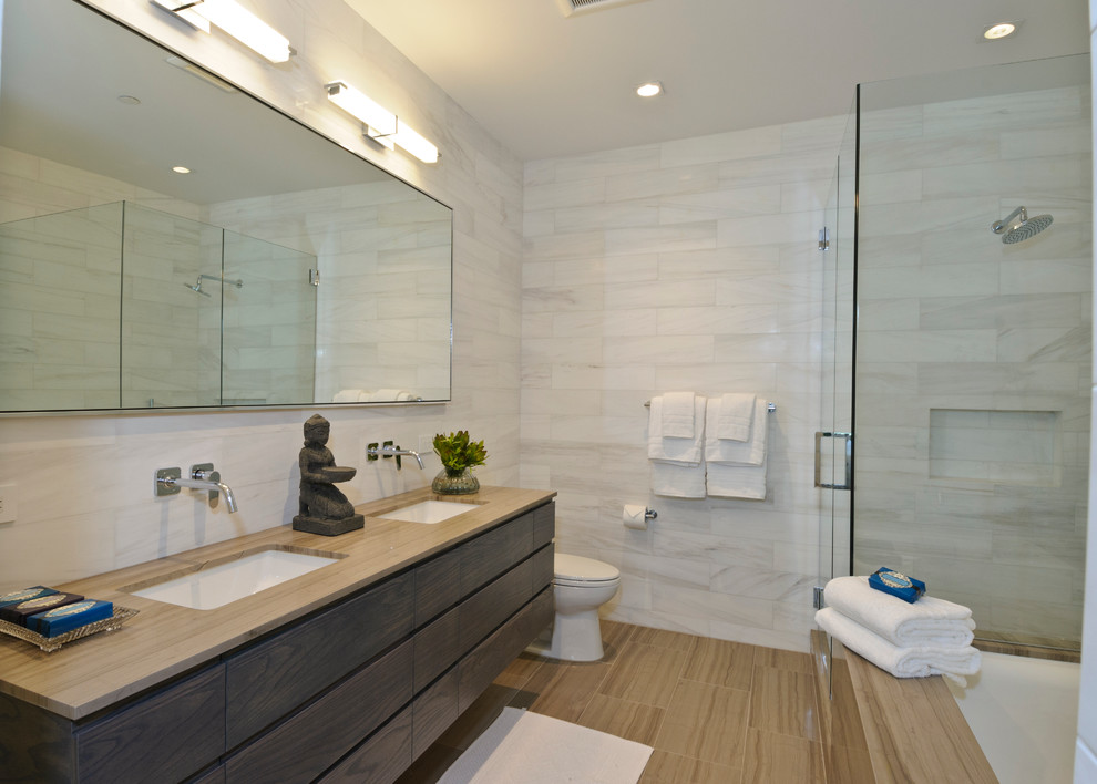 Esempio di una stanza da bagno minimal con lavabo sottopiano, ante lisce, ante in legno bruno, vasca sottopiano, doccia ad angolo e piastrelle bianche