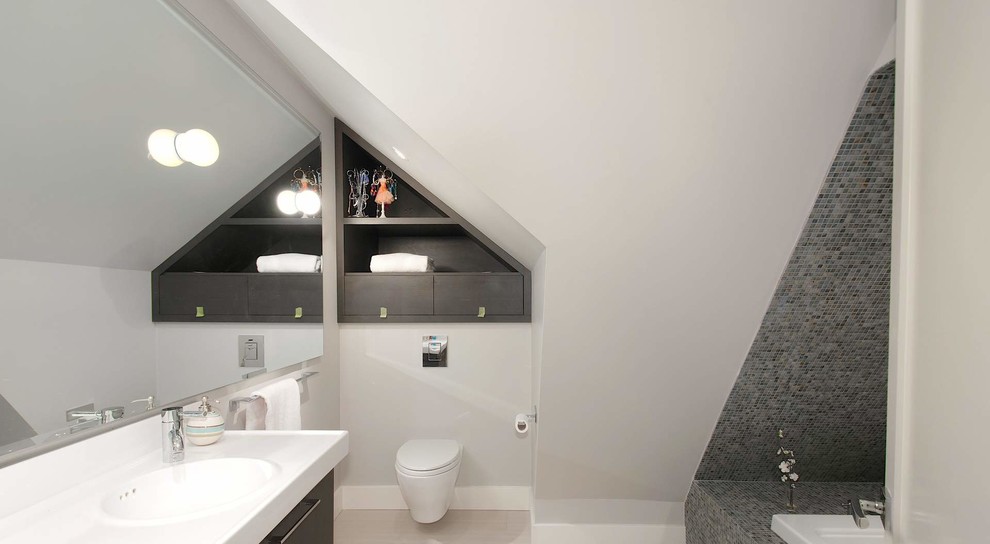 Kleines Modernes Badezimmer mit flächenbündigen Schrankfronten, dunklen Holzschränken, Einbaubadewanne, Toilette mit Aufsatzspülkasten, beigen Fliesen, Porzellanfliesen, grauer Wandfarbe, Porzellan-Bodenfliesen und integriertem Waschbecken in New York