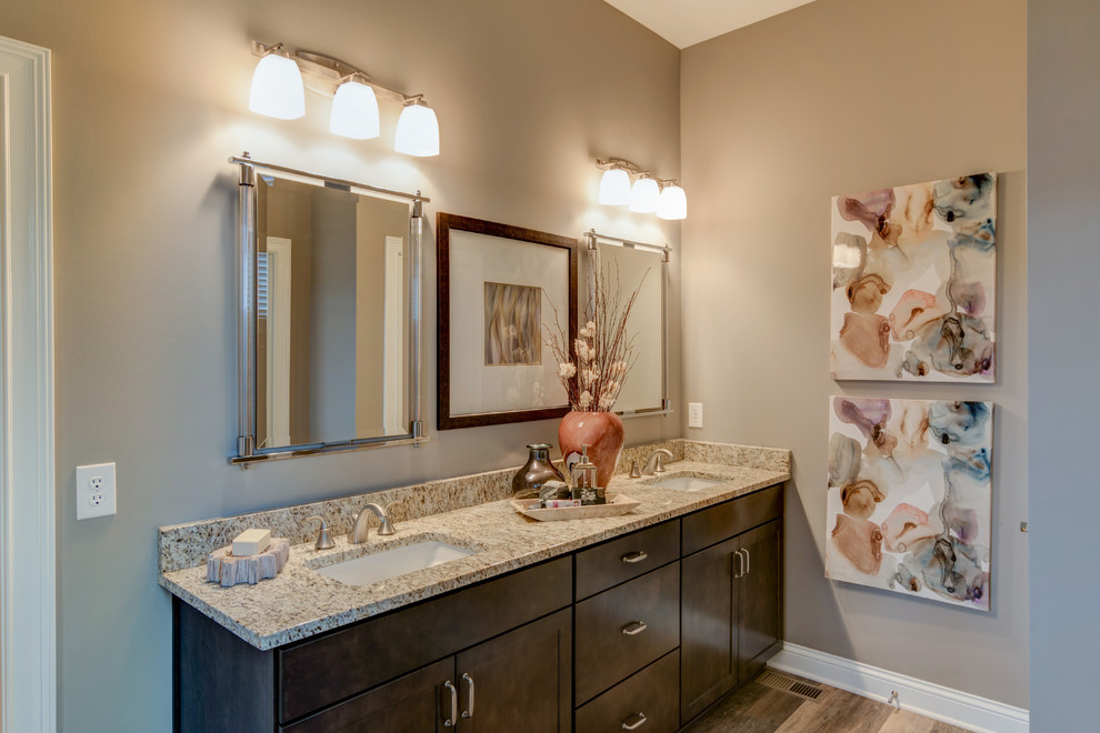 Idee per una stanza da bagno stile americano con ante in stile shaker, ante in legno bruno, pareti beige, parquet scuro, lavabo sottopiano e top in granito