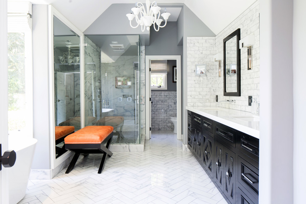 Bild på ett vintage badrum, med ett undermonterad handfat, svarta skåp, marmorbänkskiva, en dusch i en alkov, vit kakel, stenkakel, grå väggar och marmorgolv