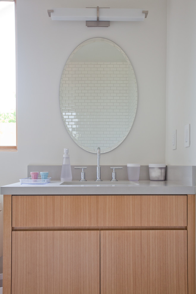 Ejemplo de cuarto de baño contemporáneo con armarios con paneles lisos y puertas de armario de madera clara