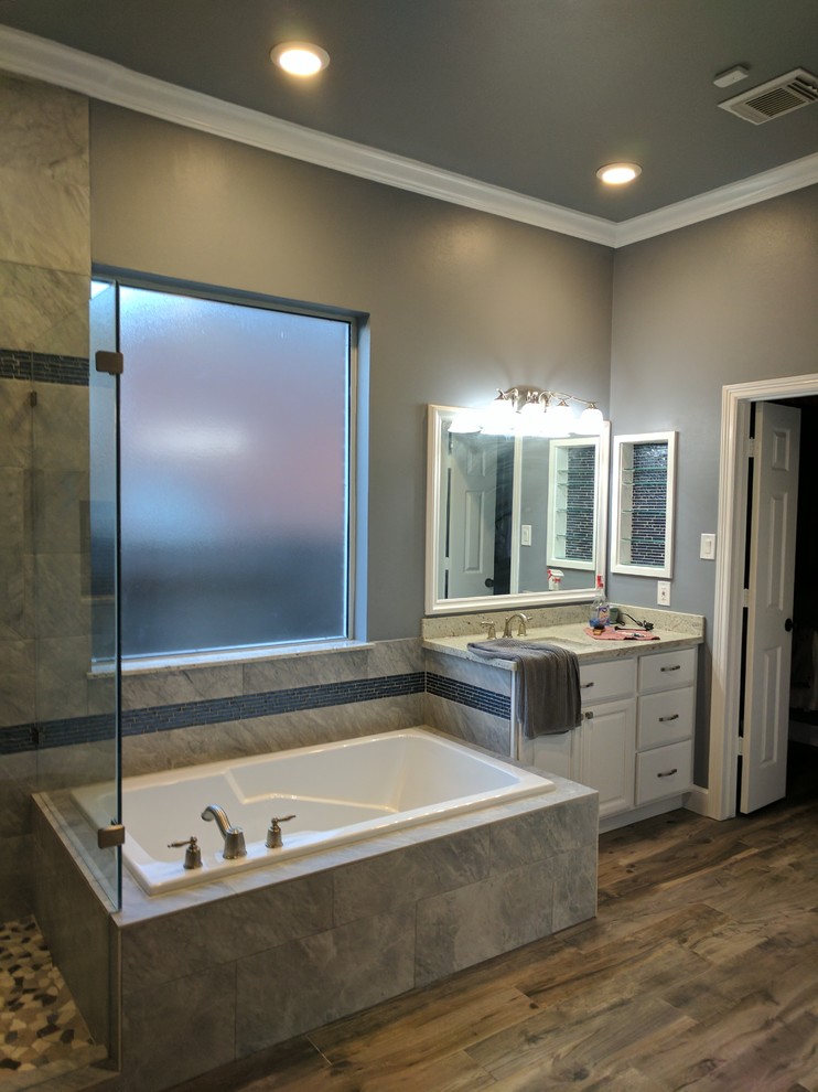 Inspiration för ett mellanstort funkis badrum, med luckor med upphöjd panel, vita skåp, ett platsbyggt badkar, en hörndusch, grå väggar, klinkergolv i porslin, ett undermonterad handfat, brunt golv och dusch med gångjärnsdörr