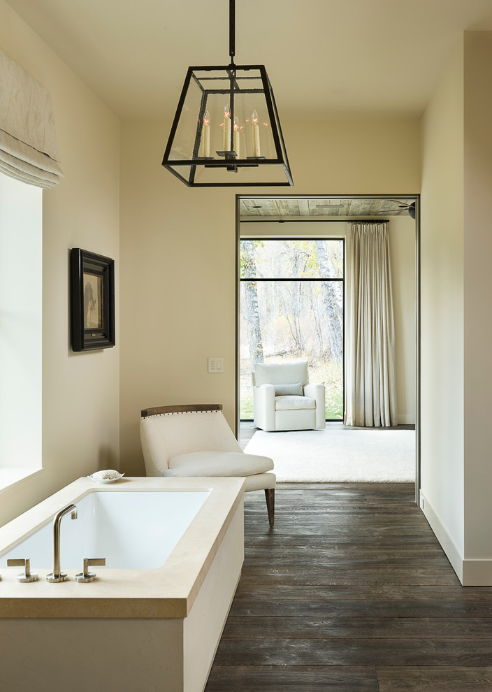 Ejemplo de cuarto de baño principal rural extra grande con bañera exenta, paredes beige y suelo de madera oscura