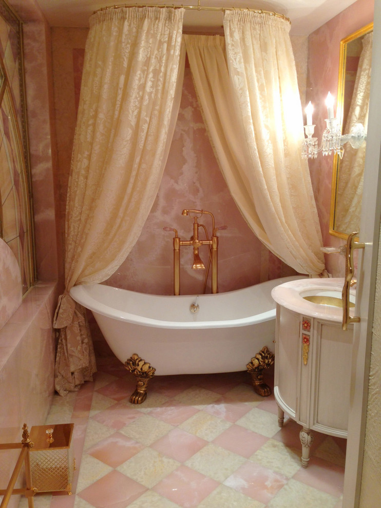 Exemple d'une salle de bain chic de taille moyenne pour enfant avec un lavabo encastré, un placard en trompe-l'oeil, des portes de placard blanches, une baignoire indépendante, un combiné douche/baignoire, WC suspendus, un carrelage rose, un carrelage de pierre, un mur rose et un sol en marbre.
