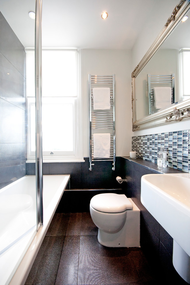 Foto på ett litet funkis badrum för barn, med ett väggmonterat handfat, ett platsbyggt badkar, en dusch/badkar-kombination, en toalettstol med hel cisternkåpa, vita väggar och klinkergolv i keramik