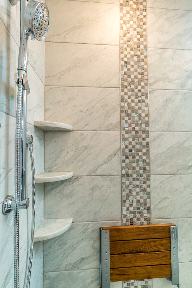 Cette image montre une grande salle de bain principale traditionnelle avec un placard avec porte à panneau surélevé, des portes de placard grises, une baignoire d'angle, une douche d'angle, WC à poser, un carrelage blanc, du carrelage en marbre, un mur gris, un sol en carrelage de céramique, un lavabo encastré et un plan de toilette en marbre.