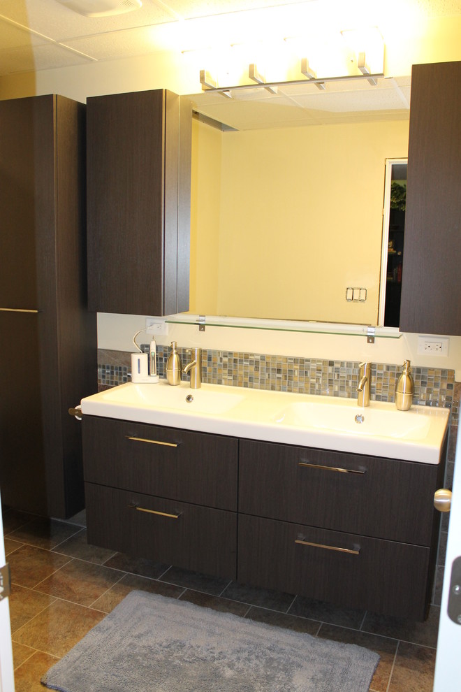 Modernes Badezimmer mit integriertem Waschbecken, flächenbündigen Schrankfronten, dunklen Holzschränken, Duschbadewanne, Toilette mit Aufsatzspülkasten und Porzellanfliesen in Denver