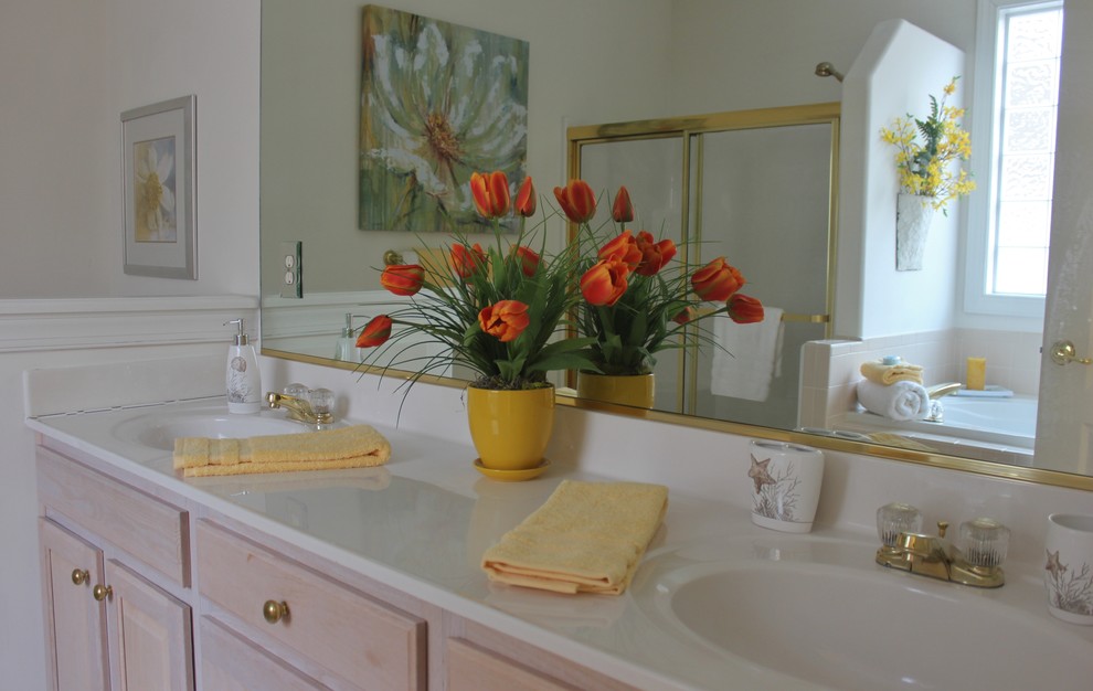 Ispirazione per una grande stanza da bagno padronale tradizionale con lavabo integrato, ante con riquadro incassato, ante in legno chiaro, vasca da incasso e pareti beige