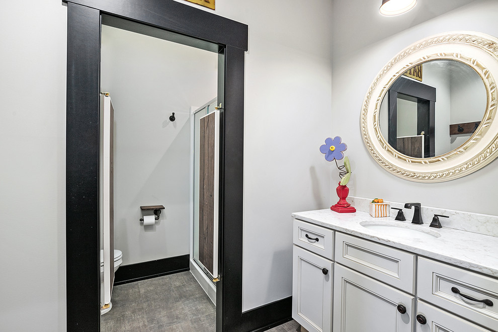 Пример оригинального дизайна: ванная комната в стиле кантри с фасадами в стиле шейкер, белыми фасадами, отдельно стоящей ванной, душем в нише, раздельным унитазом, белыми стенами, полом из винила, душевой кабиной, врезной раковиной, столешницей из искусственного кварца, серым полом, душем с распашными дверями и серой столешницей