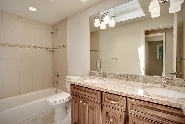 Идея дизайна: большая главная ванная комната в классическом стиле с фасадами с выступающей филенкой, темными деревянными фасадами, ванной в нише, душем над ванной, унитазом-моноблоком, врезной раковиной, столешницей из гранита и открытым душем