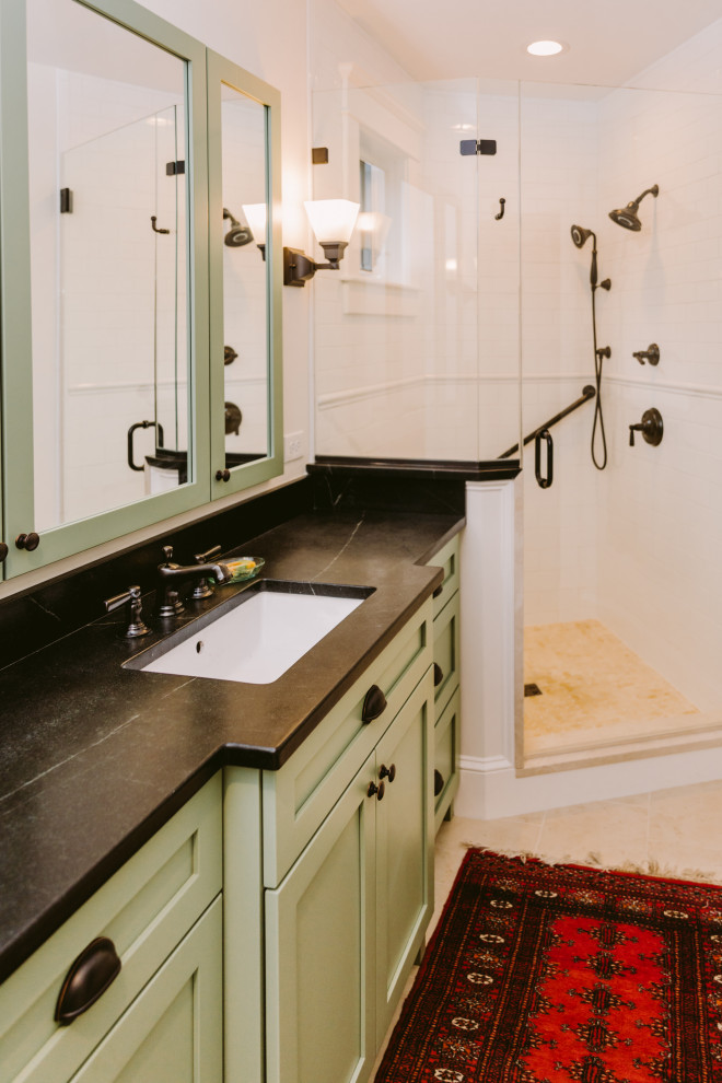 Photo of a small classic ensuite bathroom in Baltimore with shaker cabinets, green cabinets, a corner shower, a two-piece toilet, white tiles, metro tiles, white walls, travertine flooring, a built-in sink, soapstone worktops, beige floors, a hinged door, white worktops, a wall niche, a single sink and a built in vanity unit.