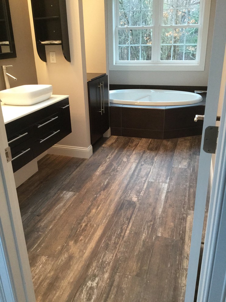 Inspiration for a large contemporary master porcelain tile drop-in bathtub remodel in Bridgeport with flat-panel cabinets, dark wood cabinets, beige walls, a vessel sink and quartz countertops