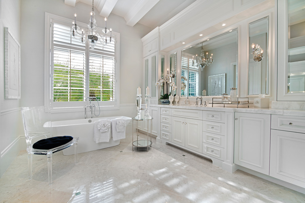 Idee per una grande stanza da bagno padronale con ante a filo, ante bianche, vasca freestanding, piastrelle bianche, pareti bianche, pavimento in marmo, lavabo sottopiano e top in marmo