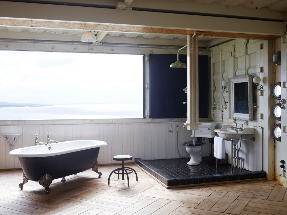 Large world-inspired bathroom in Fukuoka with a freestanding bath, a walk-in shower, black tiles, light hardwood flooring, a console sink, a two-piece toilet, white walls and an open shower.