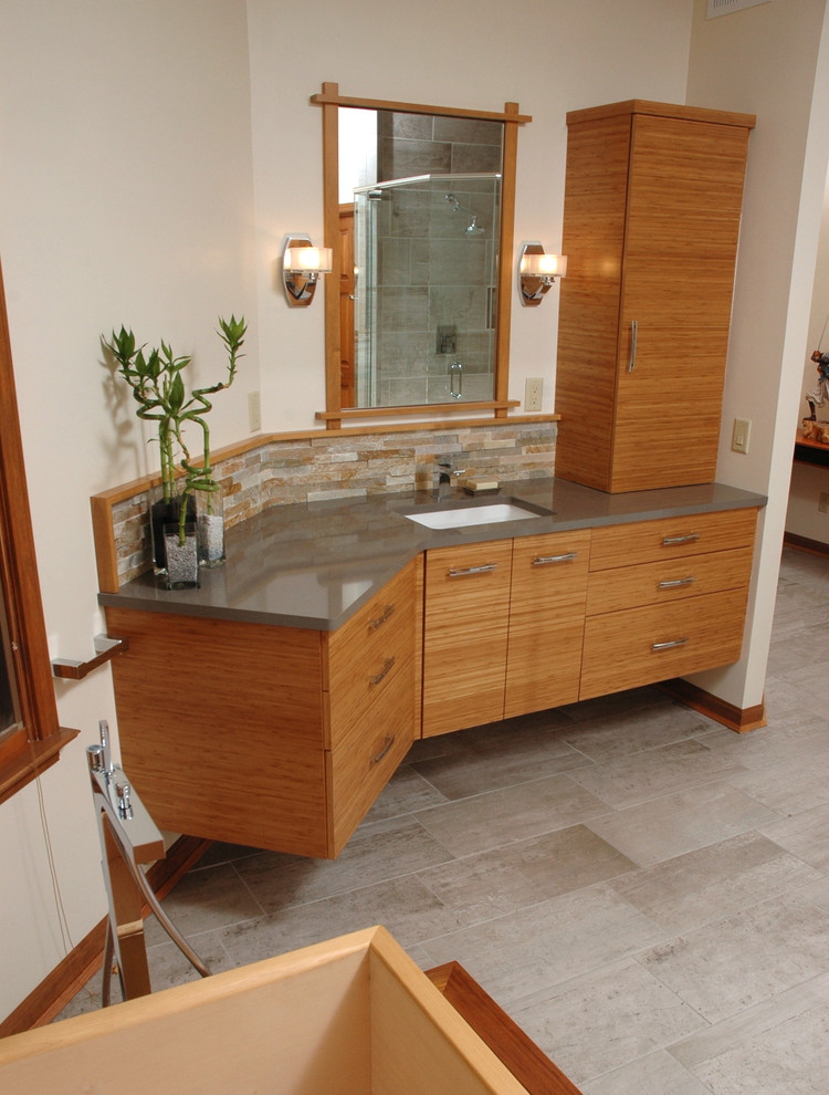 Photo of a medium sized world-inspired ensuite bathroom in Cincinnati with a submerged sink, flat-panel cabinets, light wood cabinets, multi-coloured tiles, stone tiles and beige walls.
