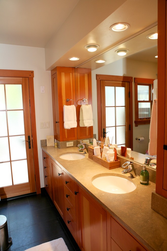 Example of a mid-sized transitional kids' green tile and stone tile slate floor bathroom design in Other with an undermount sink, recessed-panel cabinets, medium tone wood cabinets, limestone countertops, a one-piece toilet and green walls