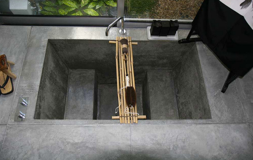 Ispirazione per una stanza da bagno etnica di medie dimensioni con vasca giapponese e pavimento in cemento