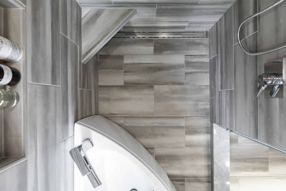 Inspiration pour une salle de bain principale minimaliste de taille moyenne avec une baignoire d'angle, un combiné douche/baignoire, un carrelage gris, des carreaux de porcelaine, un mur gris, un sol en carrelage de porcelaine, un sol gris et une cabine de douche à porte battante.