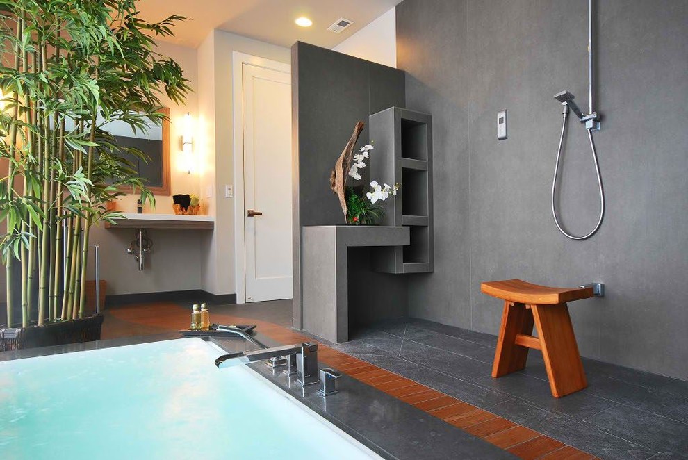 Bild på ett stort funkis en-suite badrum, med ett väggmonterat handfat, bänkskiva i kvarts, ett platsbyggt badkar, en öppen dusch, en toalettstol med hel cisternkåpa, grå kakel, porslinskakel, vita väggar och mellanmörkt trägolv