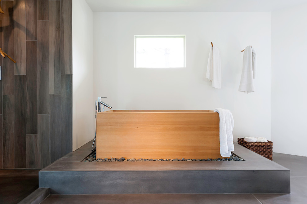 Стильный дизайн: огромная главная ванная комната в восточном стиле с японской ванной, открытым душем, серой плиткой, цементной плиткой, белыми стенами, бетонным полом, плоскими фасадами, черными фасадами, унитазом-моноблоком, раковиной с несколькими смесителями, столешницей из дерева, серым полом и открытым душем - последний тренд