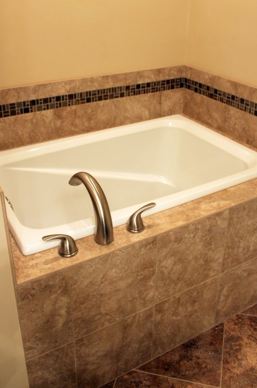 Mittelgroßes Rustikales Badezimmer En Suite mit japanischer Badewanne, braunen Fliesen, Keramikfliesen, beiger Wandfarbe und Keramikboden in Sonstige