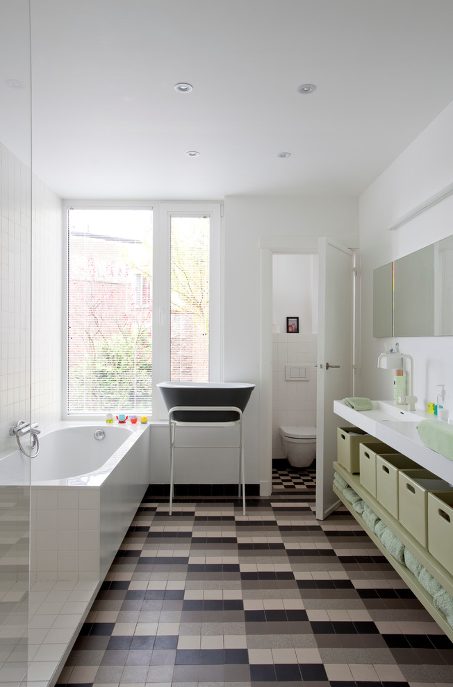 На фото: главная ванная комната в скандинавском стиле с открытыми фасадами, зелеными фасадами, накладной ванной, открытым душем, инсталляцией, белыми стенами, монолитной раковиной, разноцветным полом и открытым душем