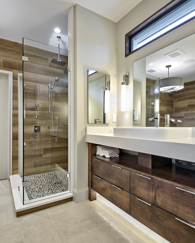 Transitional master brown tile and porcelain tile porcelain tile and beige floor corner shower photo in Austin with furniture-like cabinets, medium tone wood cabinets, brown walls, a drop-in sink, quartz countertops and white countertops