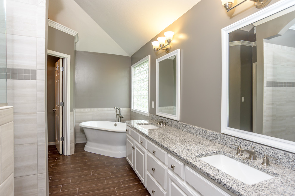 Bathroom - mid-sized transitional master gray tile and porcelain tile porcelain tile and brown floor bathroom idea in Kansas City with raised-panel cabinets, white cabinets, gray walls, an undermount sink and terrazzo countertops