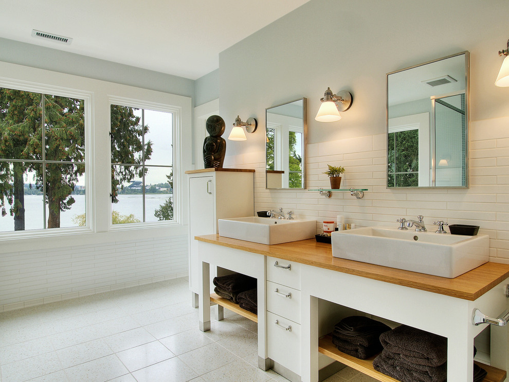 Идея дизайна: ванная комната в современном стиле с настольной раковиной, столешницей из дерева и коричневой столешницей