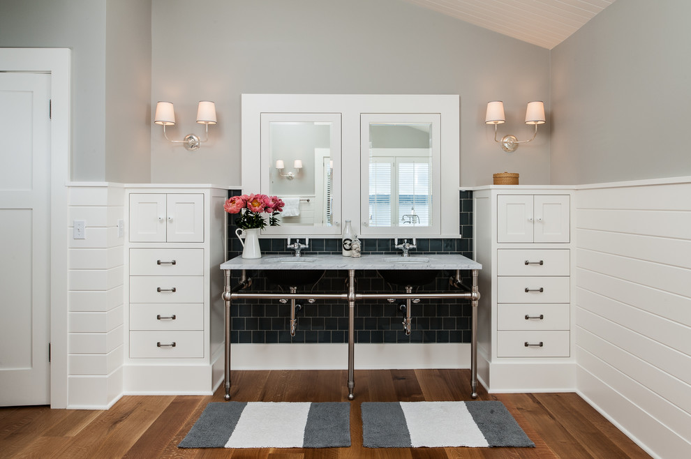 На фото: ванная комната в классическом стиле с консольной раковиной, белыми фасадами и черной плиткой