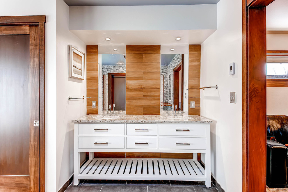 デンバーにある広いトランジショナルスタイルのおしゃれなマスターバスルーム (アンダーカウンター洗面器、白いキャビネット、フラットパネル扉のキャビネット、白い壁、スレートの床、御影石の洗面台) の写真