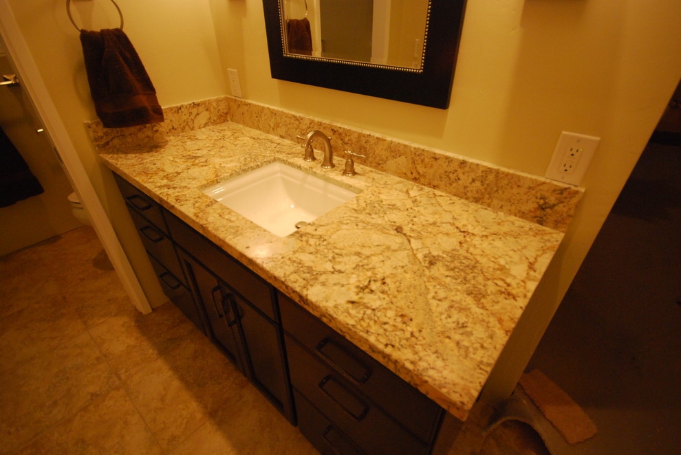 Esempio di una stanza da bagno tradizionale con lavabo sottopiano, ante in stile shaker, ante in legno bruno, top in granito, WC a due pezzi, piastrelle beige e piastrelle in gres porcellanato